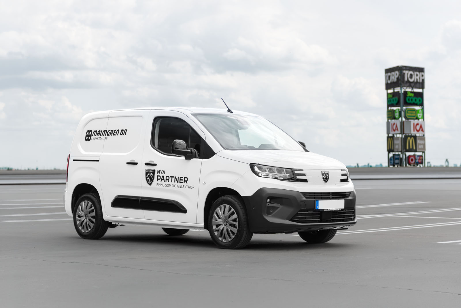 Vit Peugeot Partner från Malmgren Bil vid Torp köpcentrum i Uddevalla.